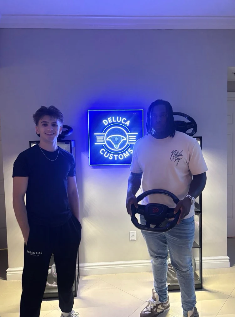 Customers at the DeLuca Customs shop under the neon sign