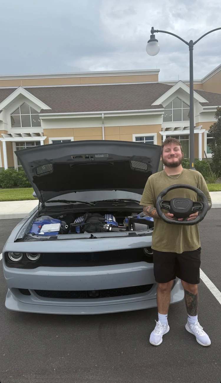 Customer holding a custom Challenger steering wheel